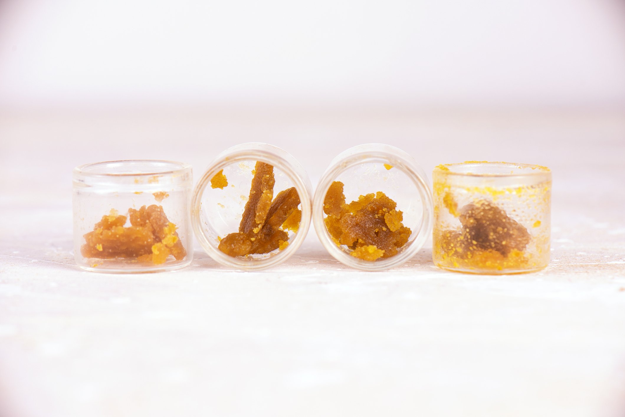 Assorted marijuana extraction concentrate aka wax crumble on jars isolated on white